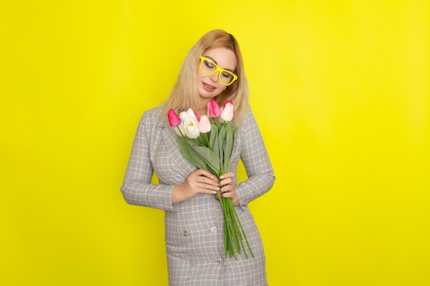 Blonde woman in plaid dress holding tulips bouquet