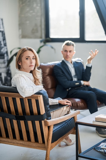 Blonde woman talking to a man at her office