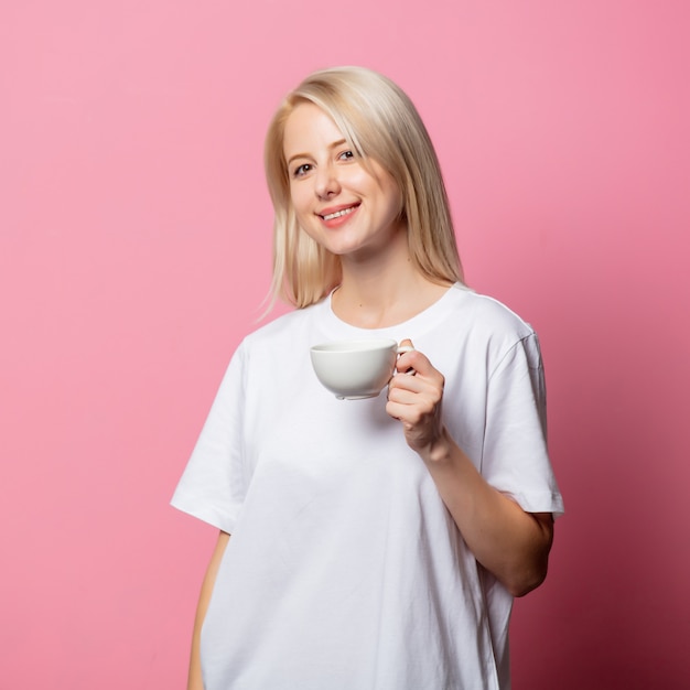 Photo blonde woman in white tshirt with cup of coffee