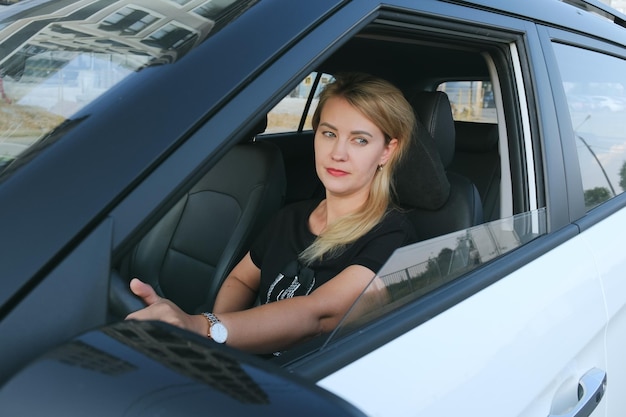 Blonde woman with bright makeup is driving a car