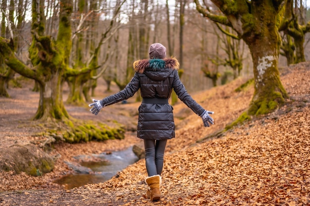 blonde woman with a long coat in a forest