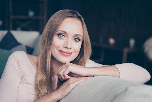 Blonde woman with long hair posing indoors in the living room