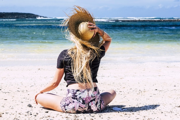 blonde young caucasian woman on the beach on vacation enjoying the sand