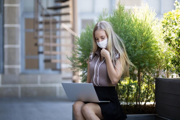 Blonde young woman using laptop computer in cafe and using internet technology online