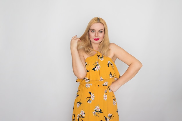 Blonde young woman in yellow floral spring summer dress