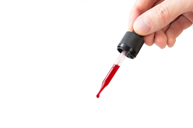 Blood dropper with red liquid in a man's hand