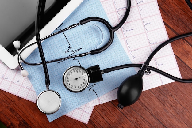 Blood pressure meter digital tablet and stethoscope on wooden background