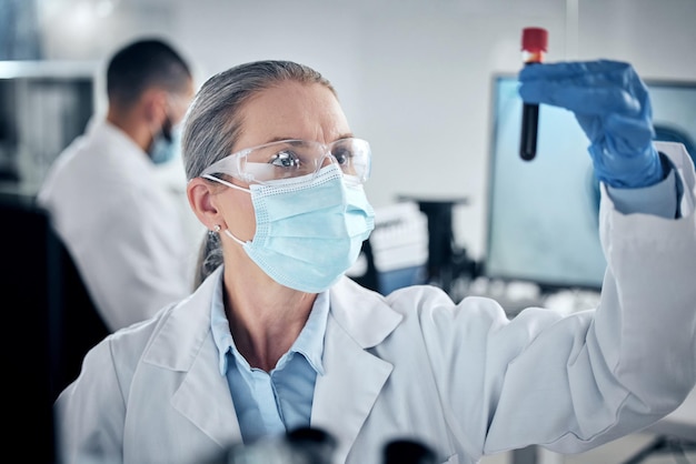 Blood test lab research and scientist working on healthcare science development with face mask for security Mature medical worker doing analysis on chemical liquid for future medicine in hospital