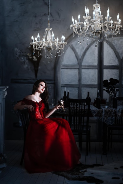 Bloodthirsty female vampire in red dress Medieval interior