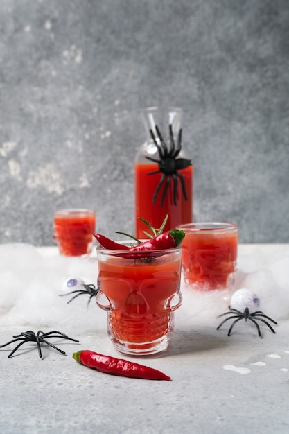 Bloody mary cocktail or tomato juice in glasses shaped like skulls