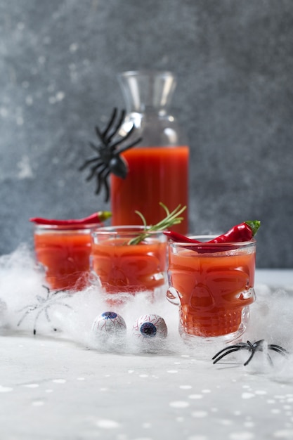 Bloody mary cocktail or tomato juice in glasses shaped like skulls