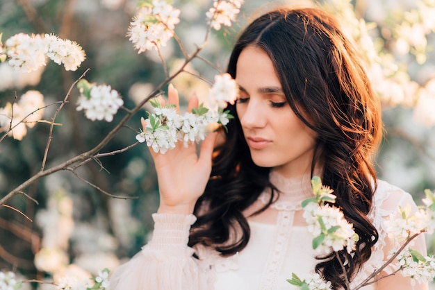 A blooming garden with a beautiful young woman in it