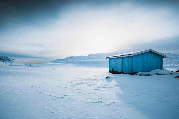 Blue abandoned wooden cabin in the snowy countryside of Greenland