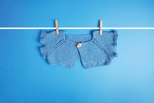 Blue baby clothes hanging on blue background