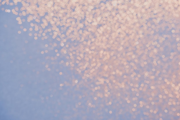 Blue background of golden glitter lights. Winter blurred abstraction.