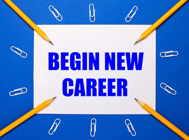 On a blue background white paper clips yellow pencils and a white sheet of paper with the text BEGIN NEW CAREER