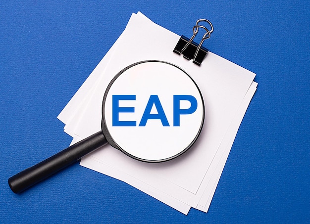 On a blue background white sheets under a black paper clip and on them a magnifying glass with the text EAP Employee Assistance Program