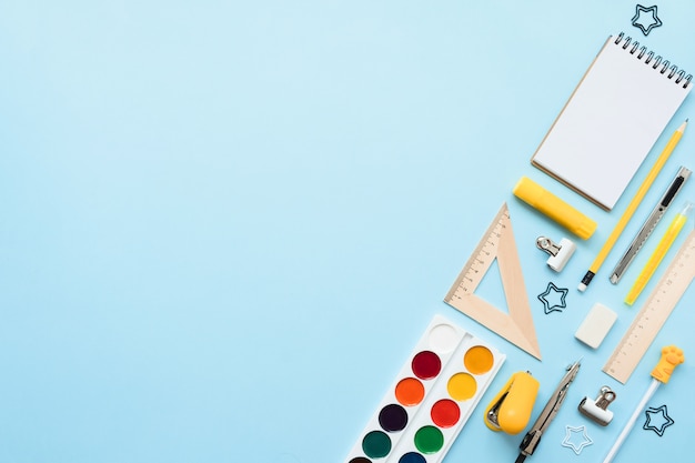 Blue background and yellow school supplies