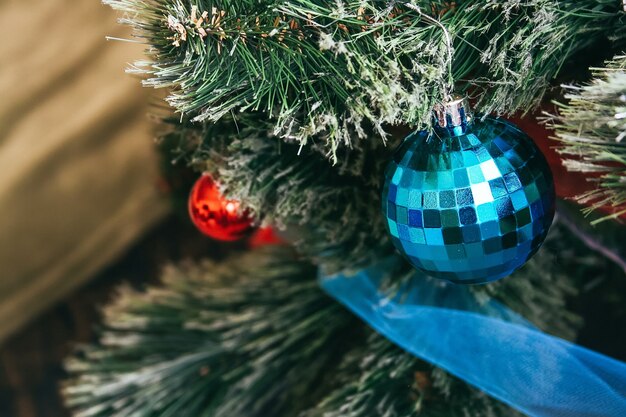 A blue ball hanging on an artificial Christmas tree