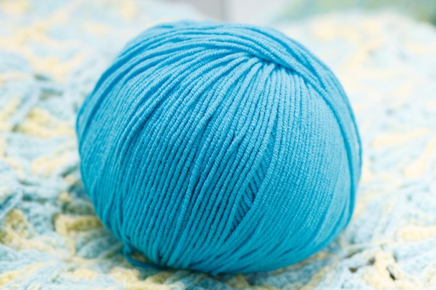 Blue ball of wool lies on a knitted napkin. High quality photo