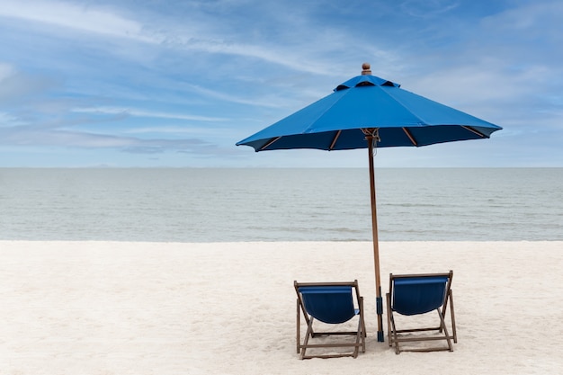 Blue beach chairs and umbrella with blue sky on the beach at tropical island