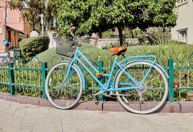 Blue bicycle locked to fence in Tel Aviv