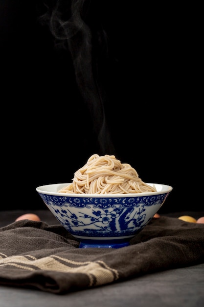 Blue bowl filled with noodle on a grey cloth