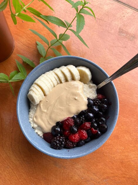 a blue bowl of oatmeal with bananas and yogurt