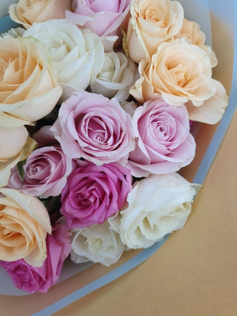 A blue bowl with pink and white roses in it.