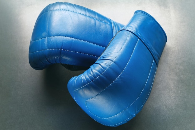 Blue boxing gloves on concrete