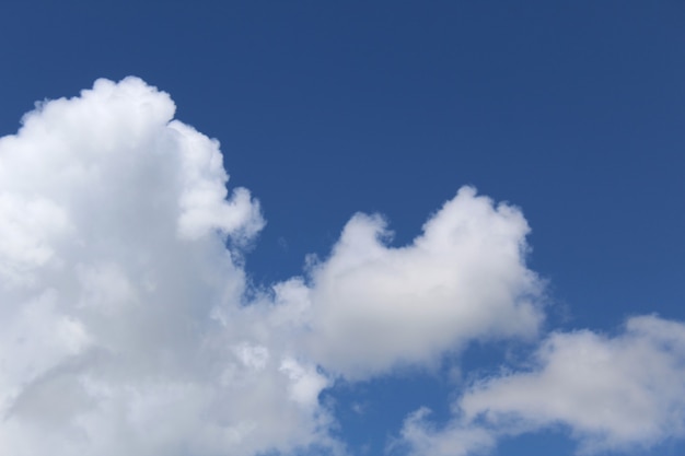 Blue bright sky with white fluffy large clouds warm sunny summer day