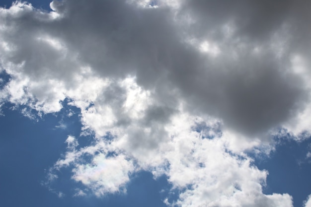 Blue bright sky with white fluffy large clouds warm sunny summer day