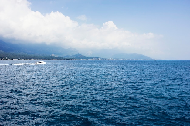 Blue calm Mediterranean Sea, mountains and white yacht