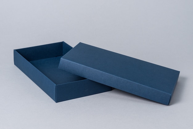 Blue carton gift box with cover, on grey background