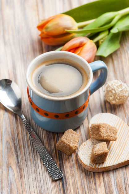 Blue ceramic cup of black hot coffee with brown sugar