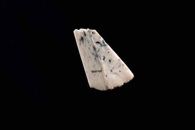 Blue cheese dor bleu or roquefort mold cheese on black isolate lifestyle food