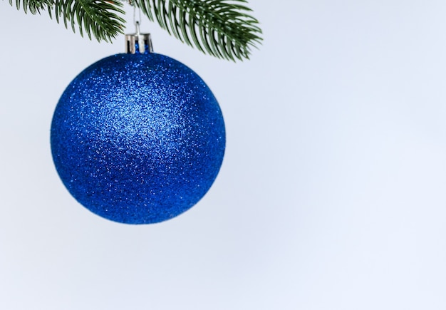 Blue Christmas ball decoration hanging on pine branch