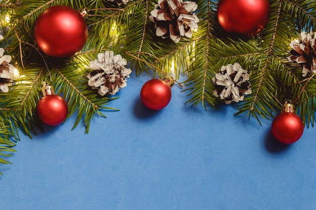 Blue Christmas composition with fir branches, baubles and cones