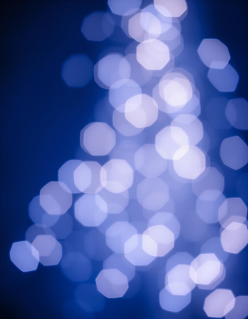 a blue christmas tree with lights in the background