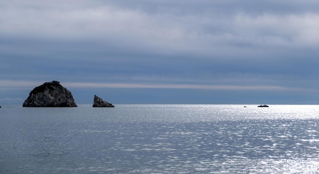 Blue cloudy sky and sea aerial drone view Small rock islands in endless blue