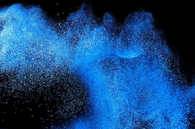 Blue color powder explosion on black background.