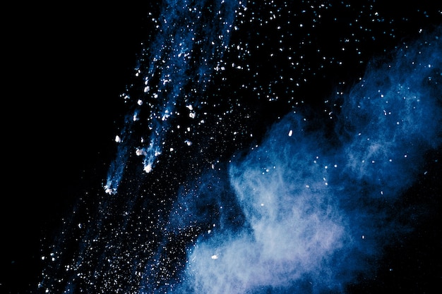 Blue color powder explosion on black background.