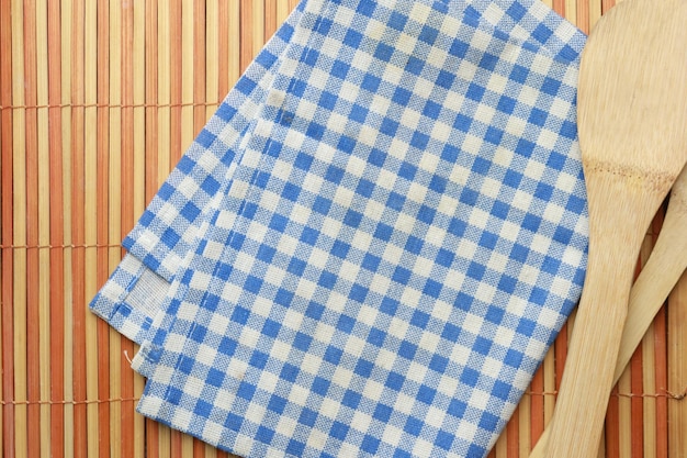 Blue color table napkin and wooden spoon on table