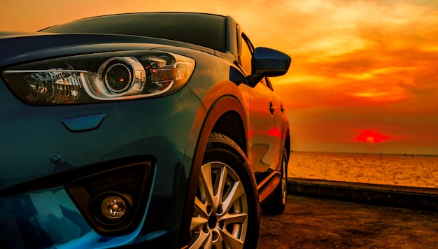 Blue compact SUV car with sport and modern design parked on concrete road by the sea at su