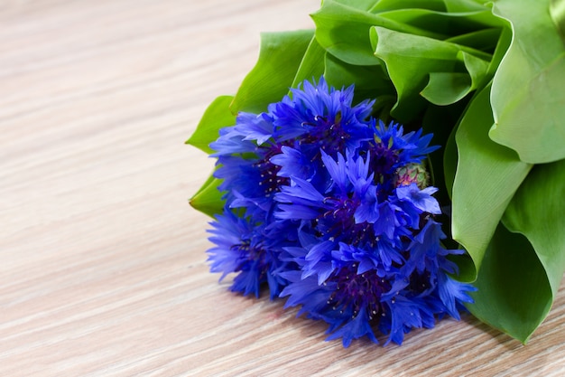 Blue corn flowers on wooden table