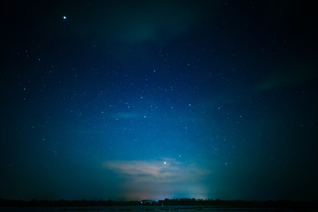 Photo blue and dark night with bright many star over lake