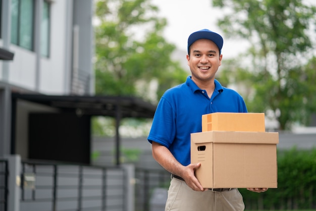 Blue Delivery asian man holding parcel cardboard box