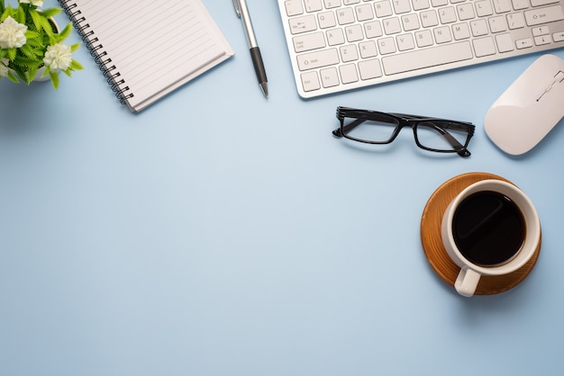 Blue desk minimal style with coffee glasses notebook keyboard Copy space.