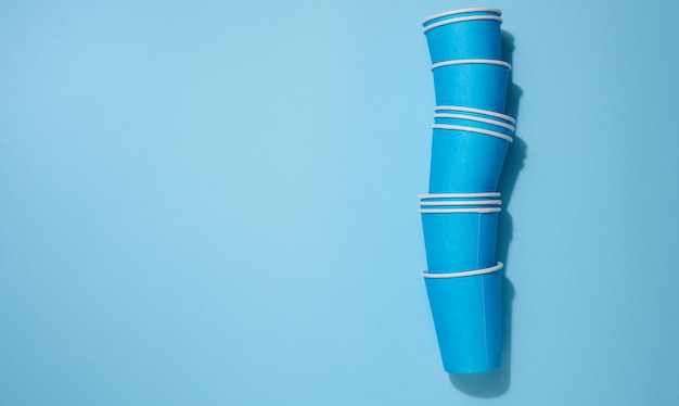 Blue disposable cups for coffee and tea on a beige background top view