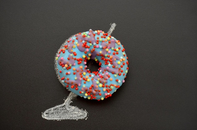 Blue donut and globe drawn on a black chalkboard creative image